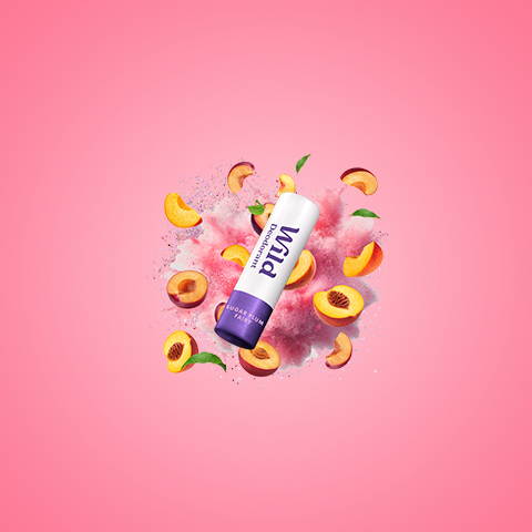 Légende : un tube de beurre à lèvres entouré de pêches