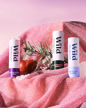 Caption: three lip bales sitting on top of a pink blanket