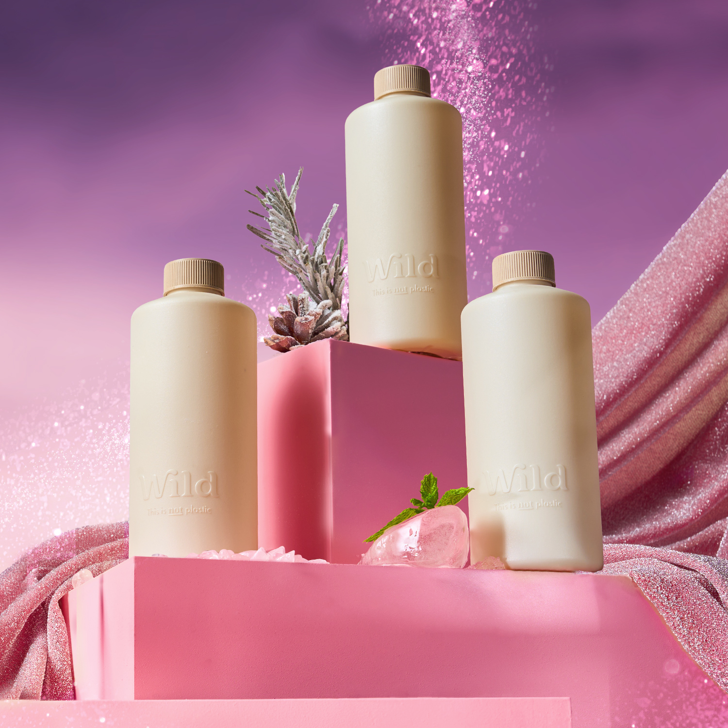 Didascalia: un gruppo di tre bottiglie sedute sopra una scatola rosa