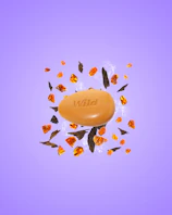Caption: an orange soap sitting on top of a purple surface