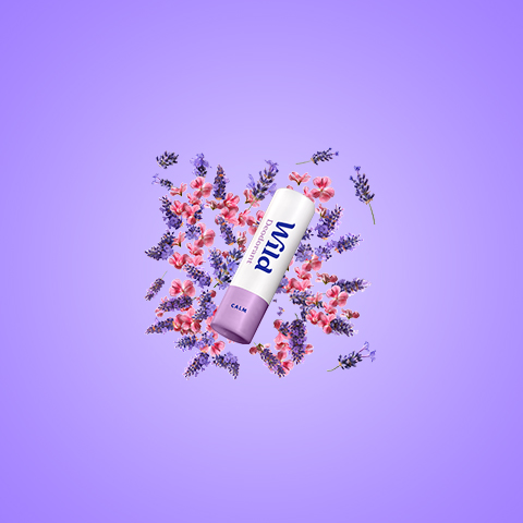 Bildunterschrift: eine Tube Lippenbalsam, umgeben von Blumen
