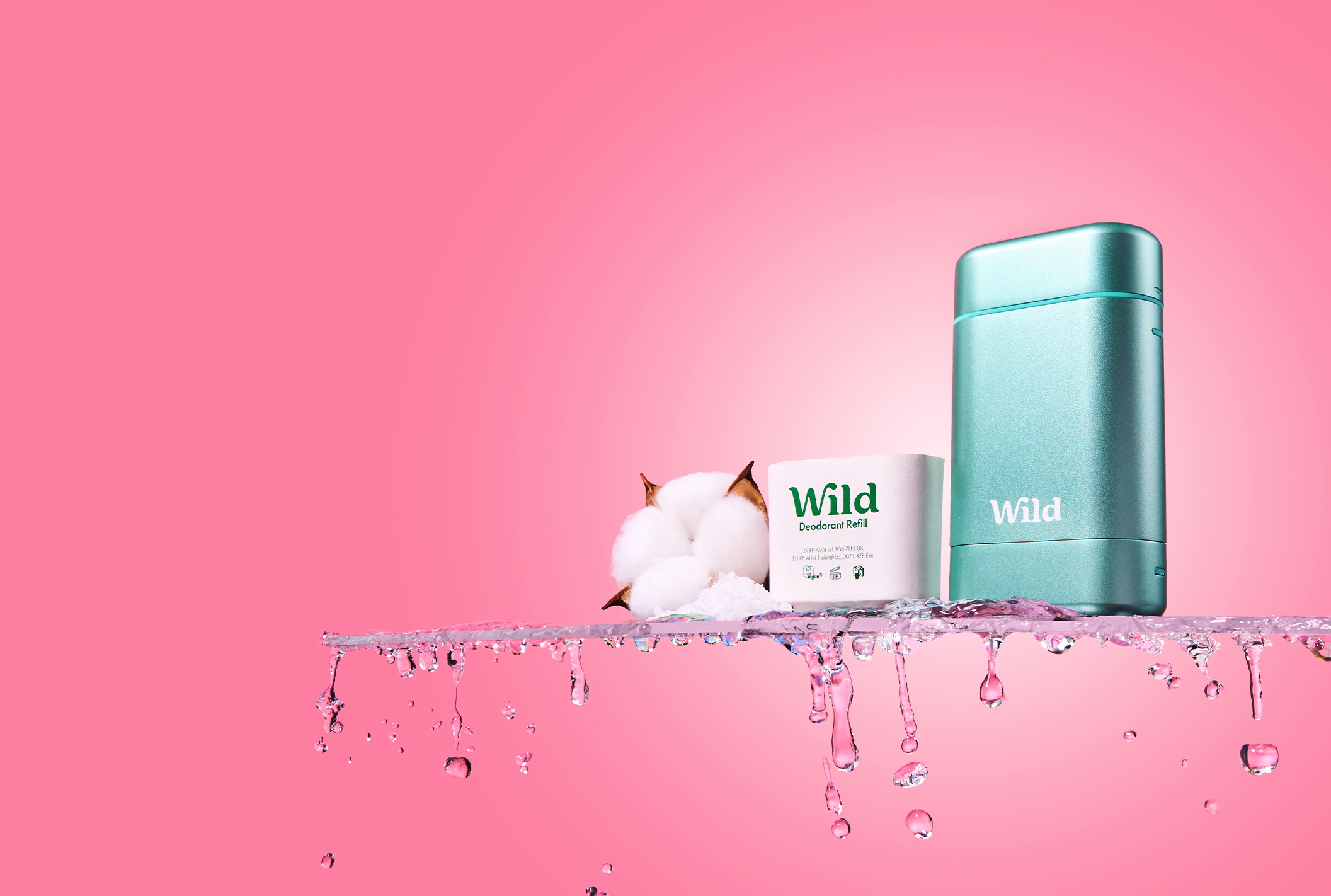 Pie de foto: un fondo rosa con una botella de salvaje y un rollo de papel higiénico