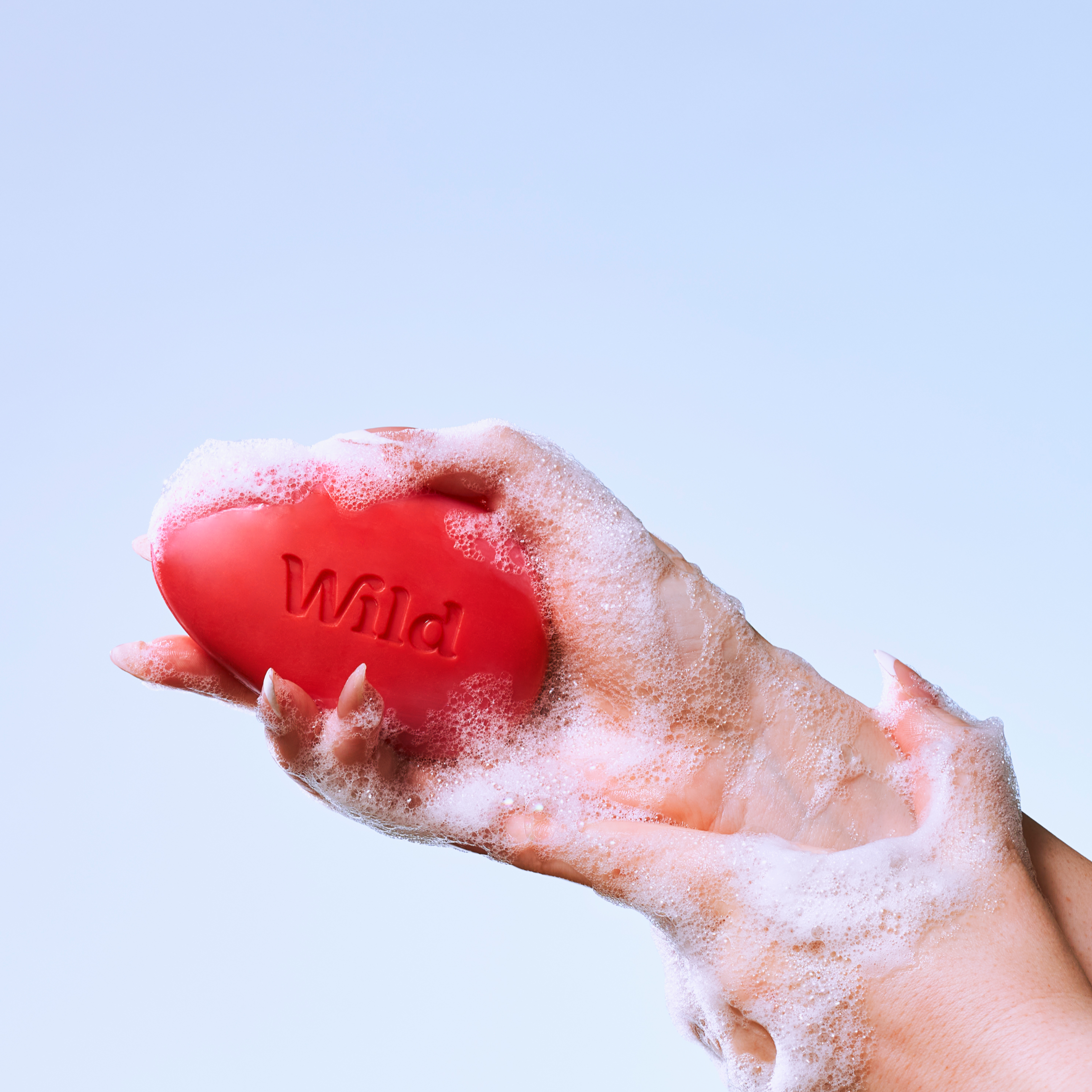 Caption: a person holding a red ball in their hand