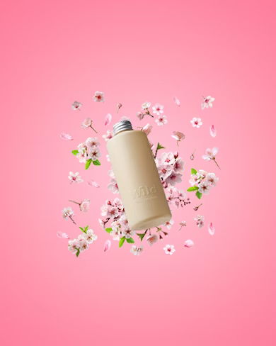 Caption: a pink background with flowers and a bottle