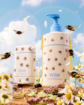 Caption: a couple of bottles sitting on top of a field of flowers