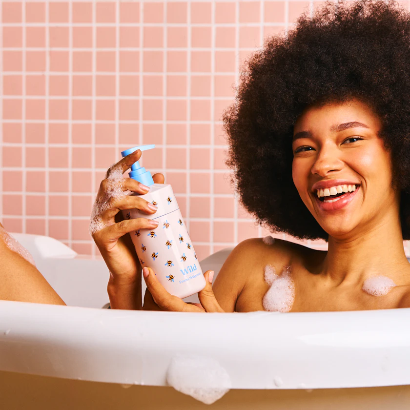 model in bath with bee body wash case