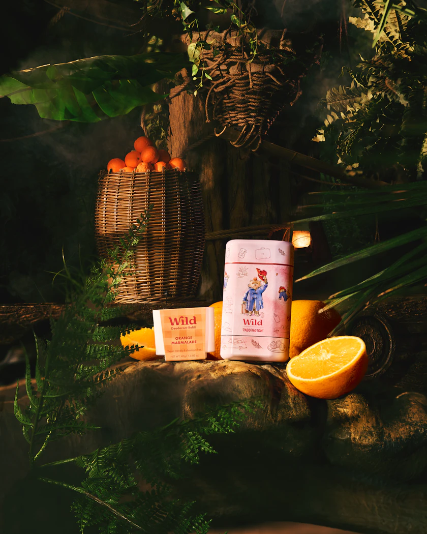 Bildunterschrift: eine Tüte Orangensaft neben einem Korb mit Orangen