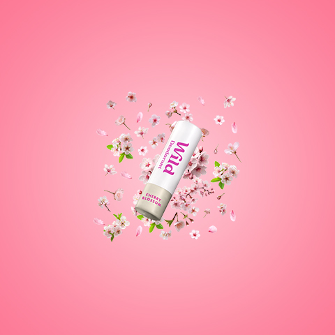 Caption: a tube of toothpaste surrounded by flowers on a pink background