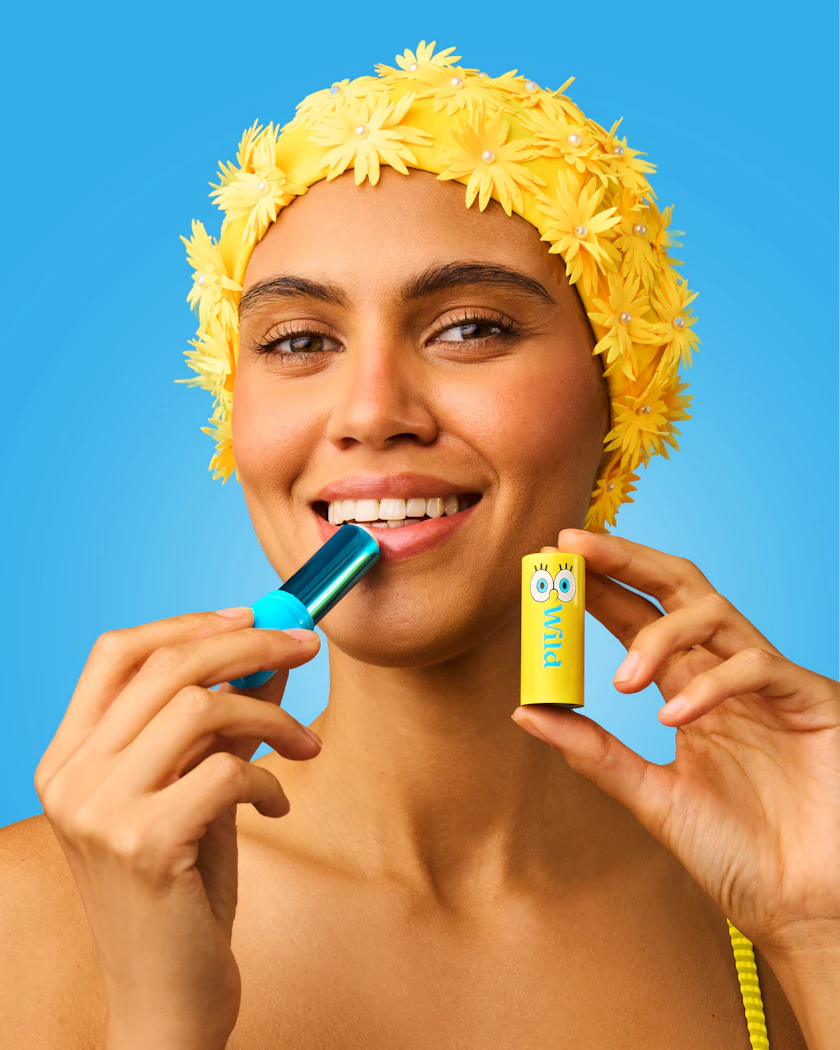 Caption: a woman in a yellow bathing suit is brushing her teeth