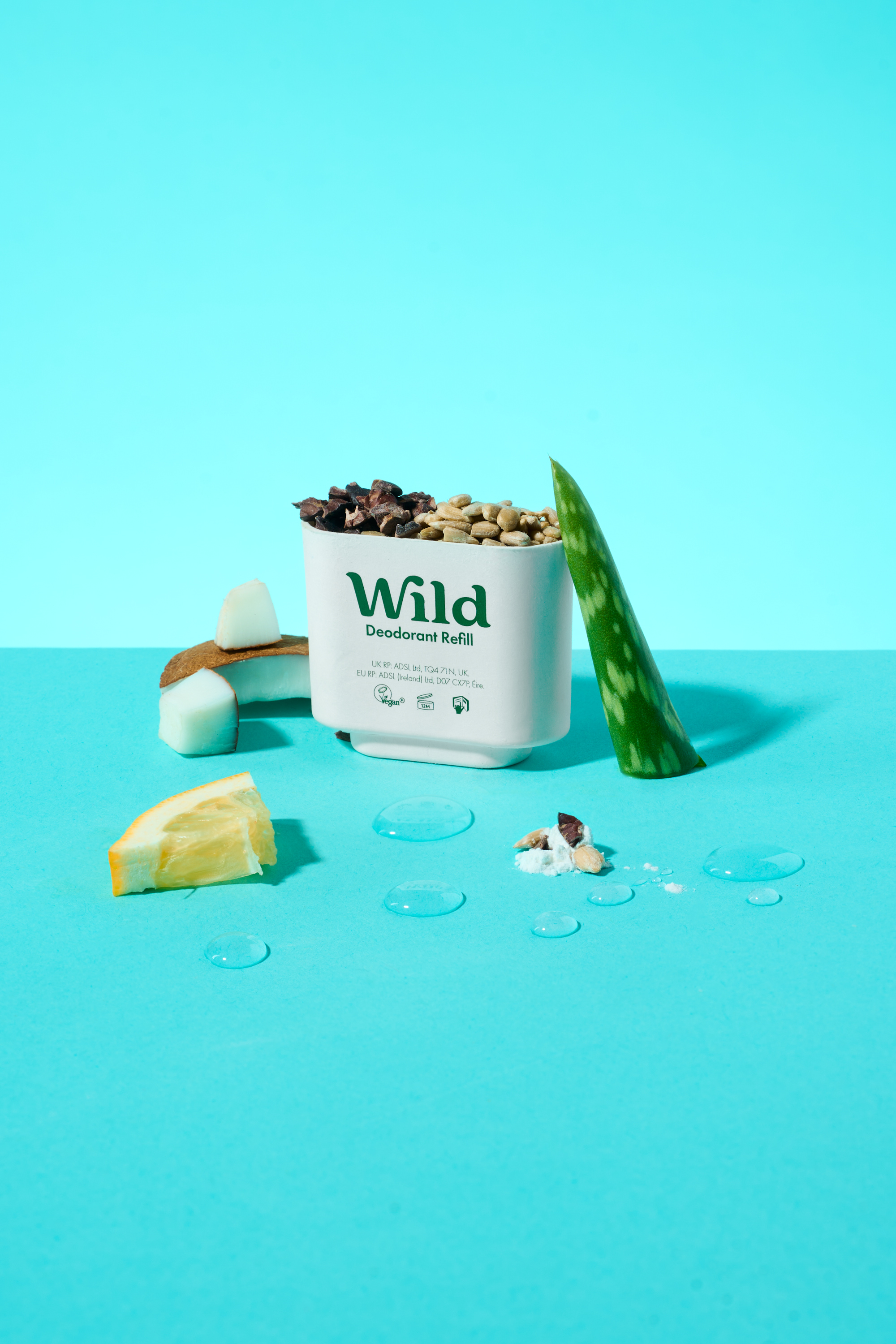 Caption: a container of wild granola next to a slice of lemon