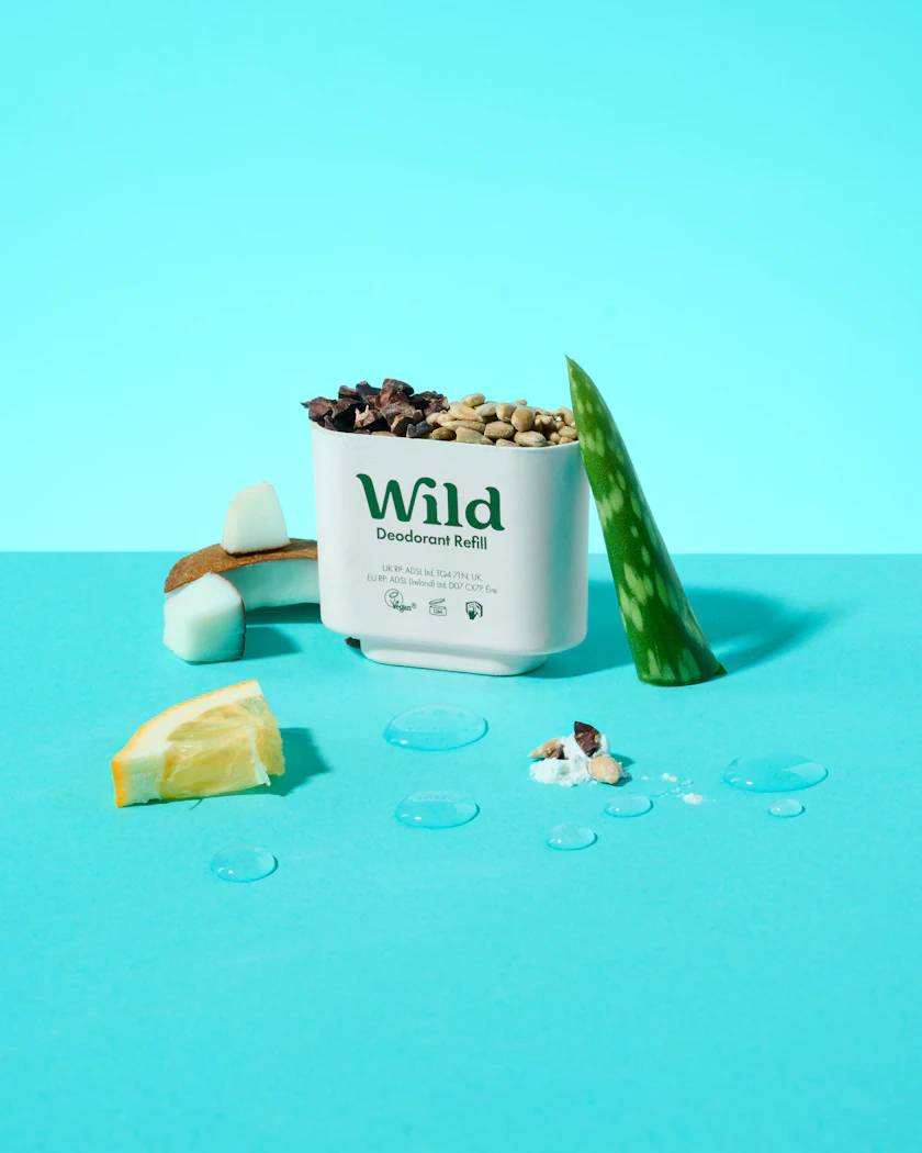 Caption: a container of wild granola next to a slice of lemon