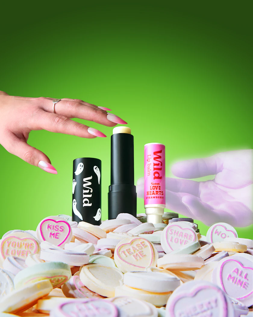 Caption: a woman's hand reaching for a lipstick on top of a pile of buttons