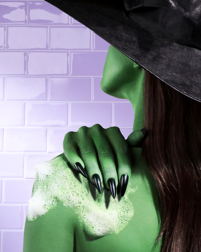 Caption: a woman wearing a green costume and a black hat