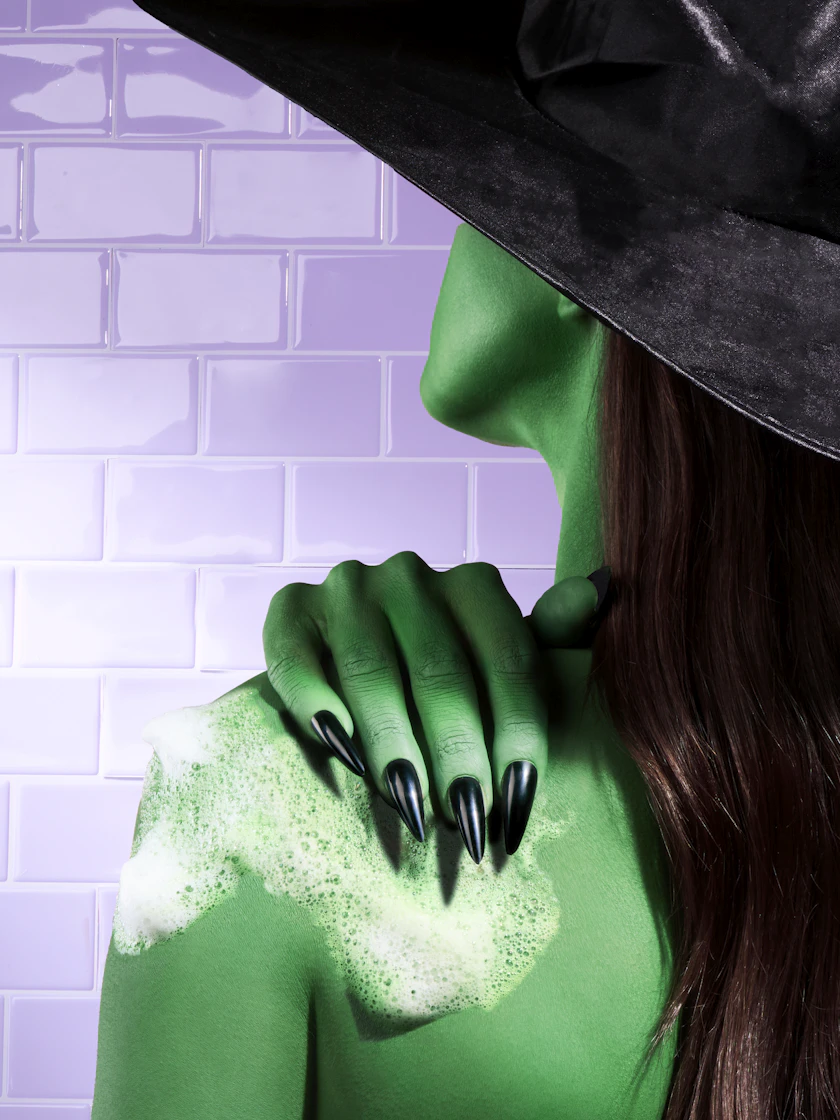 Caption: a woman wearing a green costume and a black hat