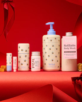 Caption: a red table topped with bottles of body wash and lotion