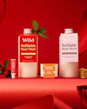 Caption: a red table topped with three bottles of body wash