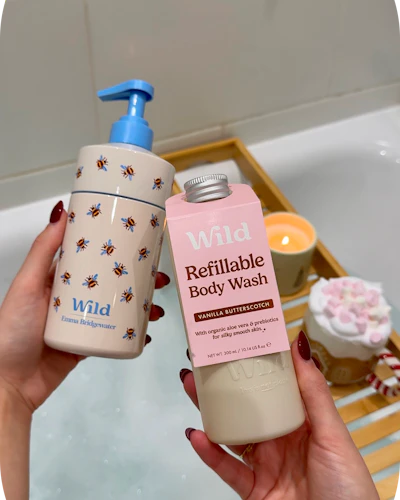 Caption: a woman holding a bottle of hand sanitizer next to a bathtub