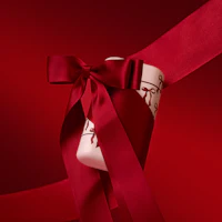Bijschrift: een rood lint is rond een bel geknoopt