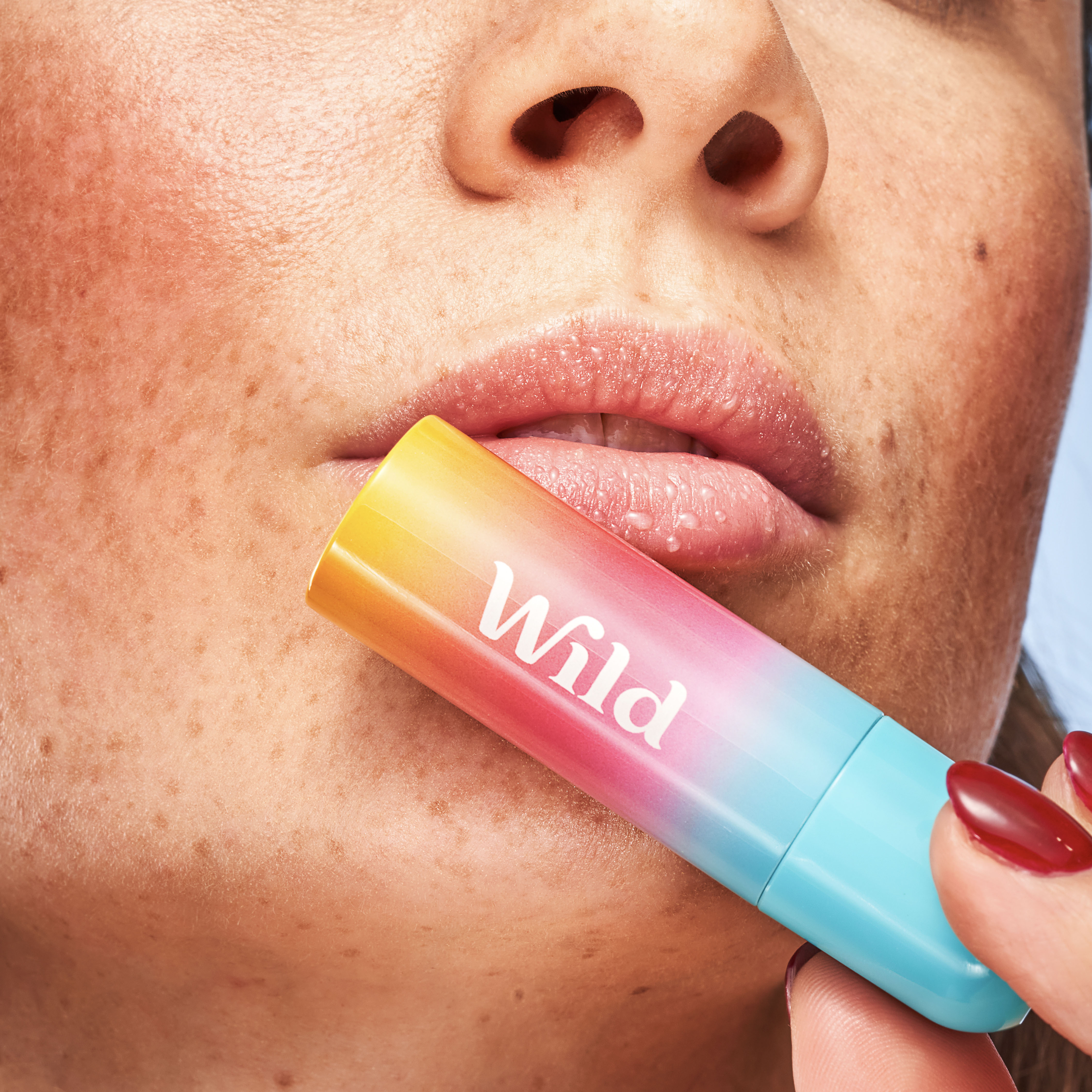 Caption: a woman putting a lip balm on her lip