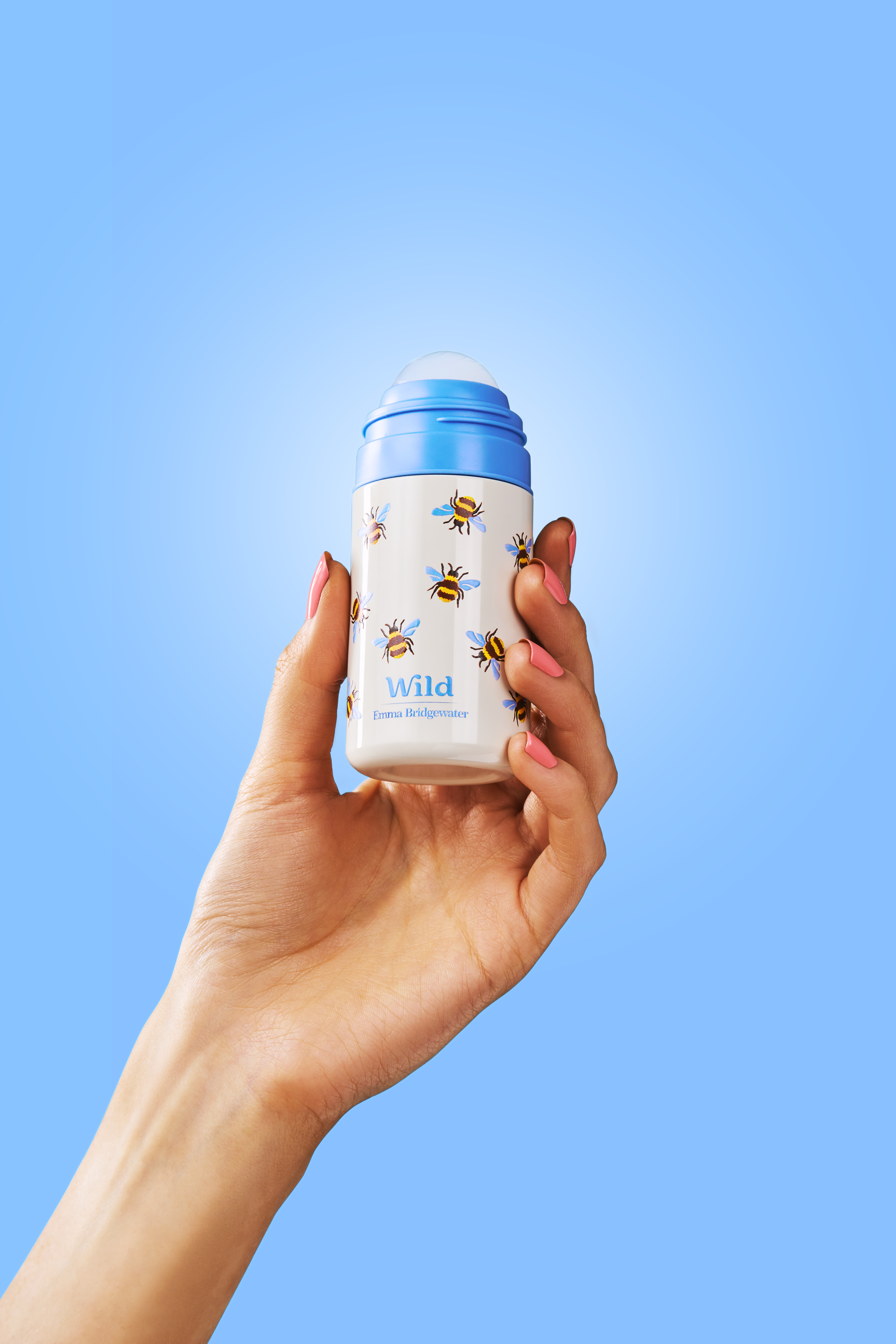 Caption: a hand holding a blue and white cup with bees on it