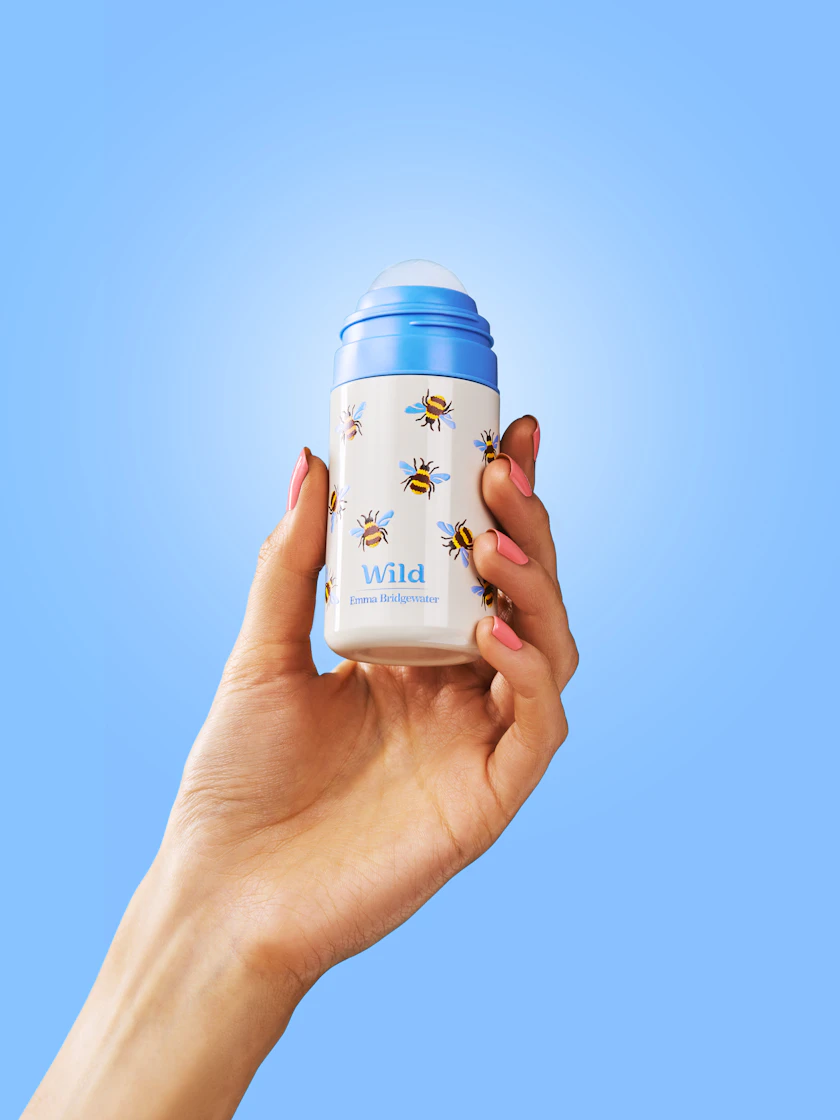 Caption: a hand holding a blue and white cup with bees on it