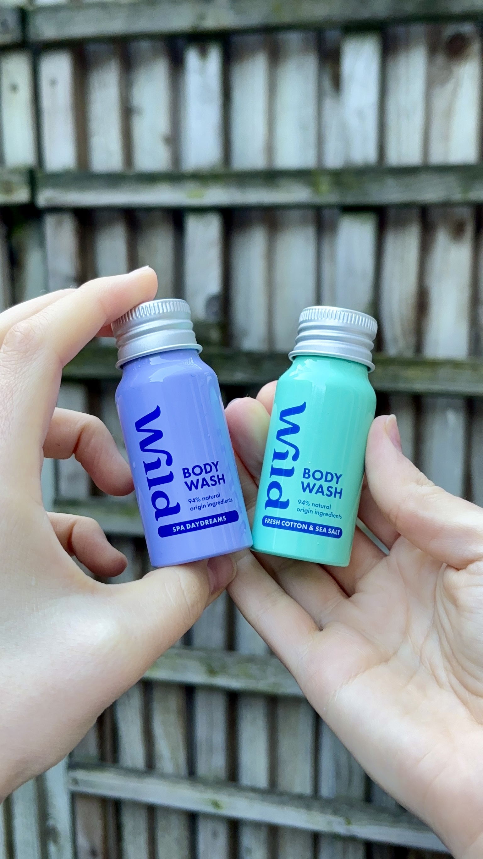 Caption: two hands holding two small bottles of toothpaste