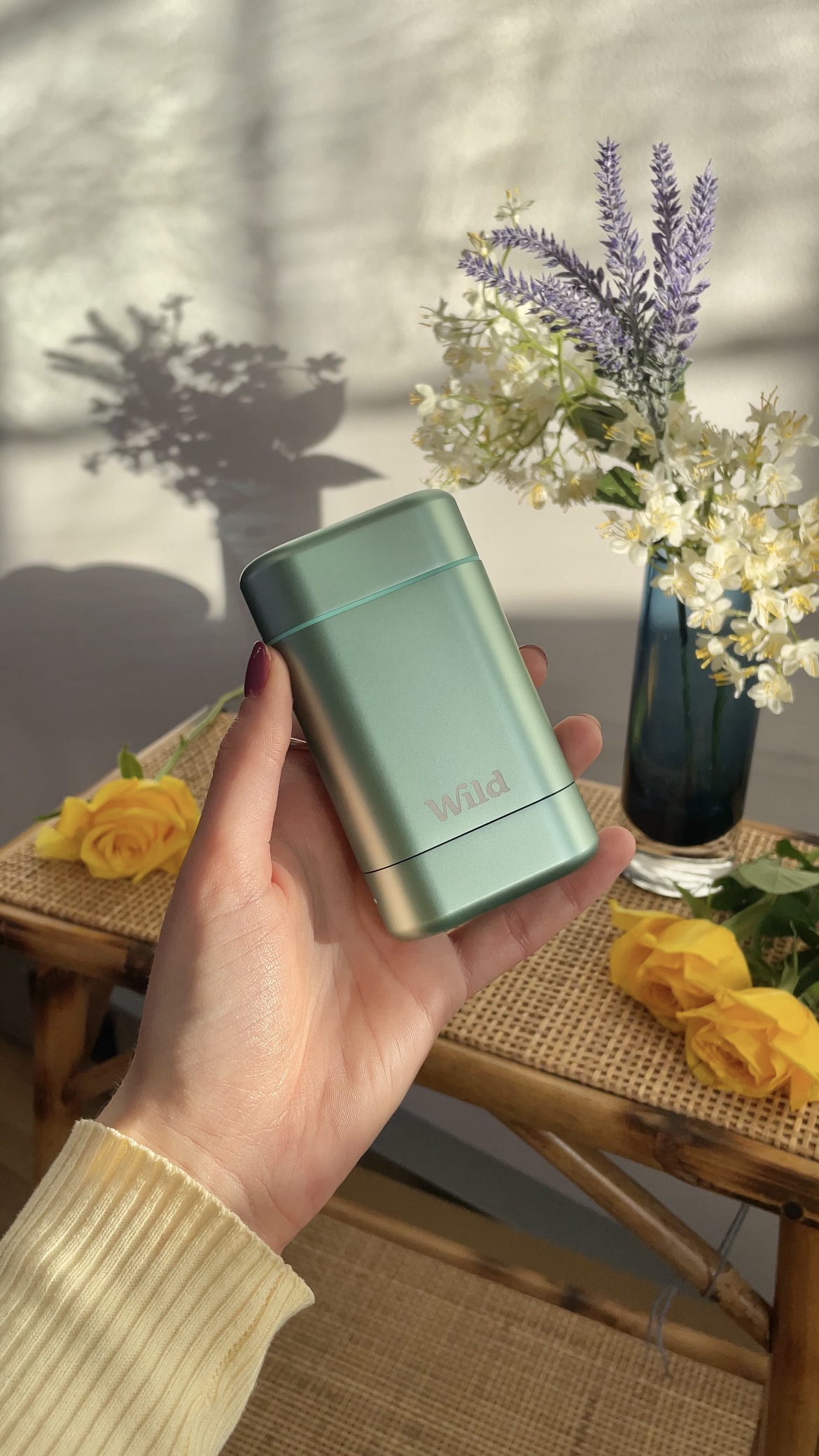 Caption: a person holding a lighter next to a vase of flowers