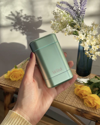 Caption: a person holding a lighter next to a vase of flowers