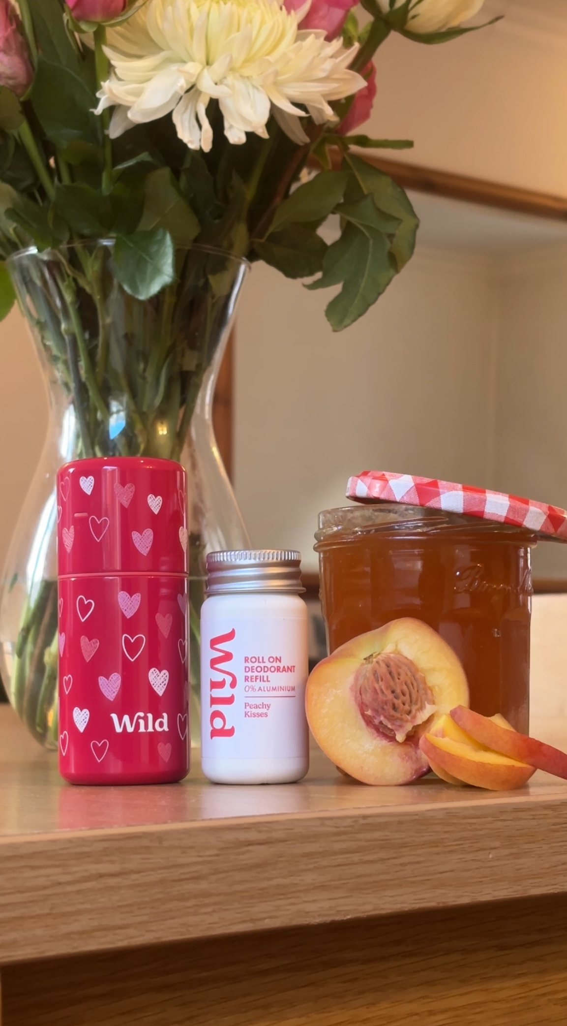 Caption: a vase filled with flowers next to a jar of honey