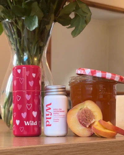 Caption: a vase filled with flowers next to a jar of honey