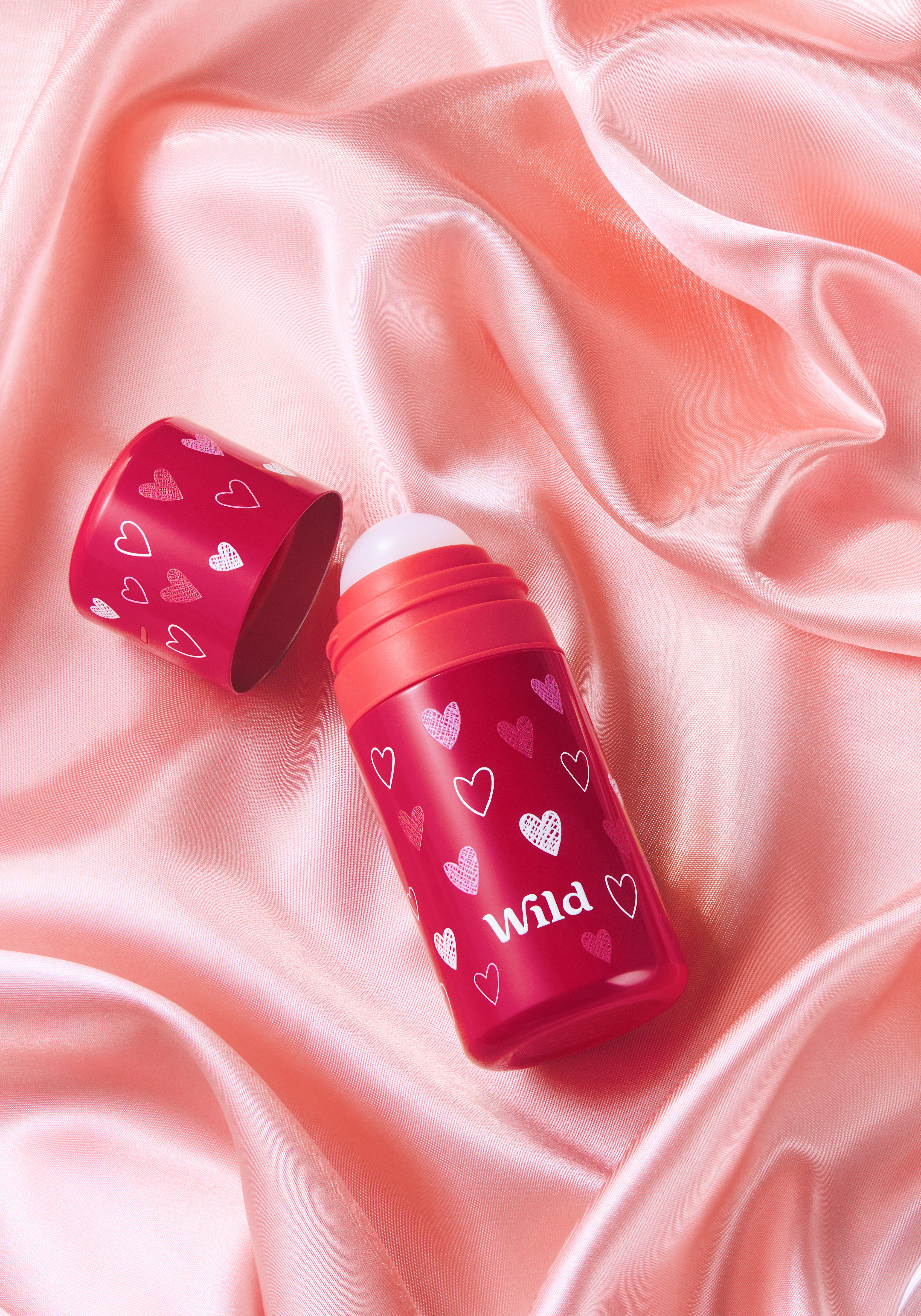 Caption: a couple of lipstick bottles sitting on top of a pink cloth