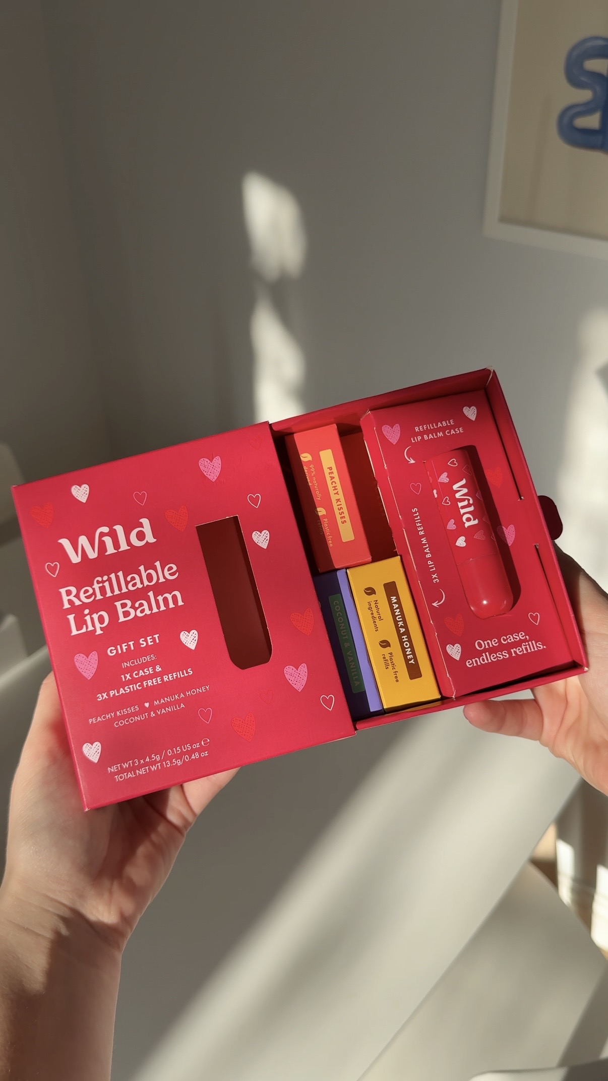 Caption: a person holding a red box with four different items in it