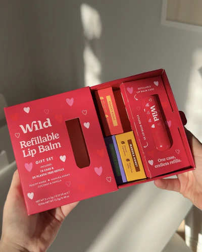 Caption: a person holding a red box with four different items in it