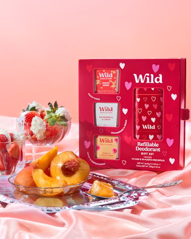 Caption: a table topped with a bowl of fruit next to a box of wild