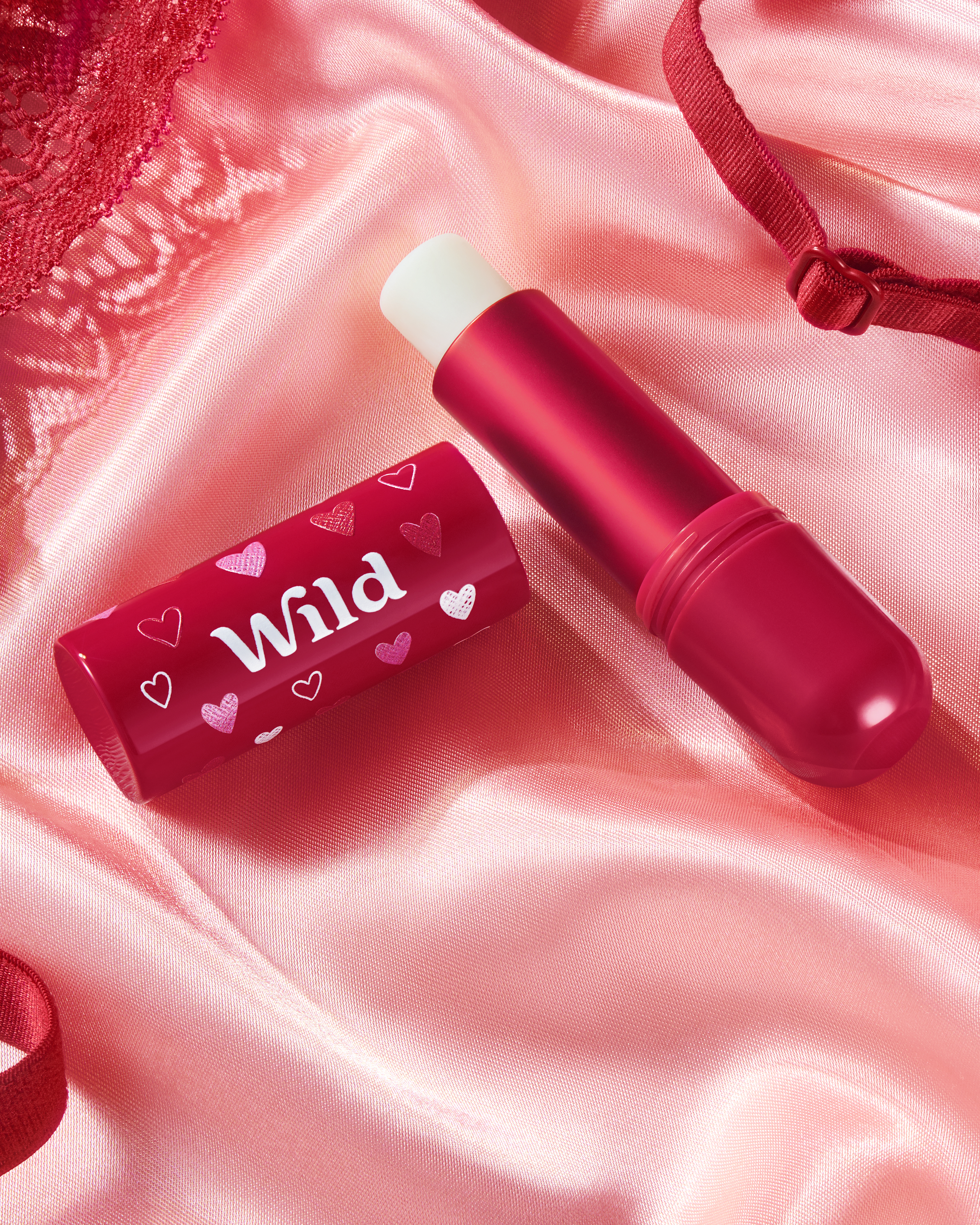 Caption: a pink lipstick with a white tube on top of it