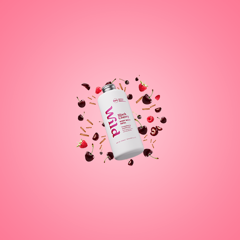 Bildunterschrift: rosa Hintergrund mit einer Flasche Pflaumenmilch, umgeben von Bonbons und Kirschen
