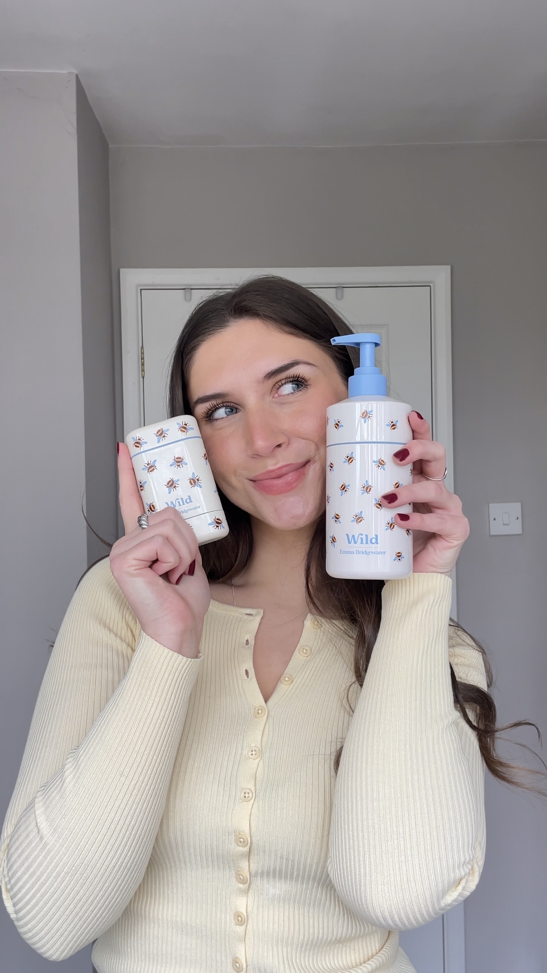 Caption: a woman holding two bottles of hand sanitizers