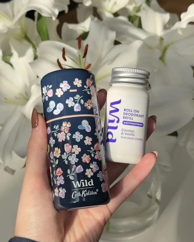 Bildunterschrift: Eine Person, die ein Glas mit weißen Blumen hält.