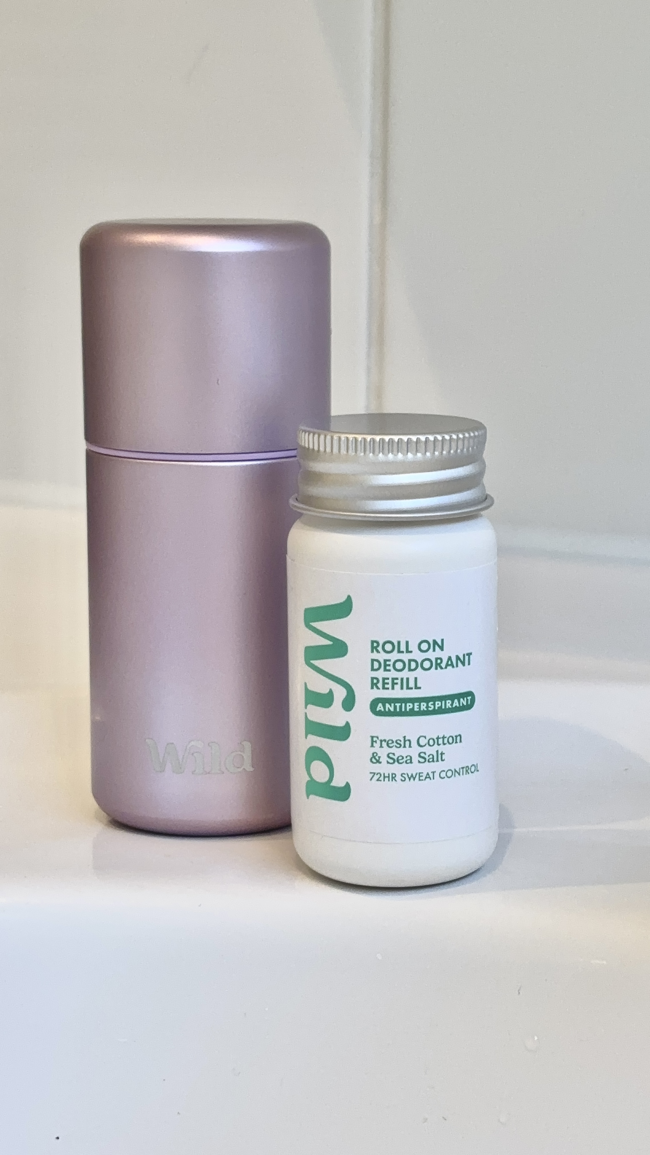 Caption: a bottle of lotion next to a container of lotion
