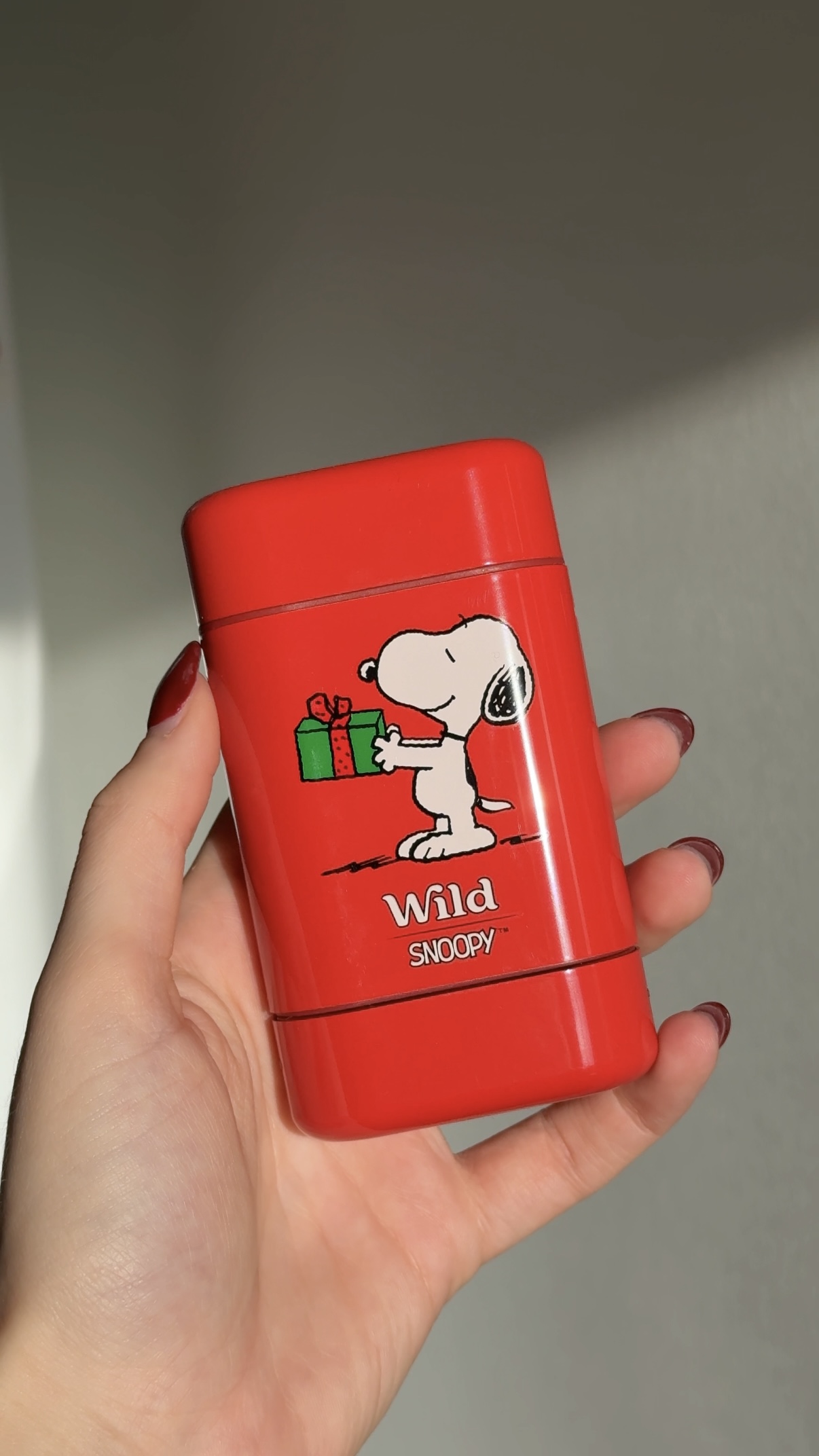 Caption: a woman holding a red lighter with a snoopy dog on it