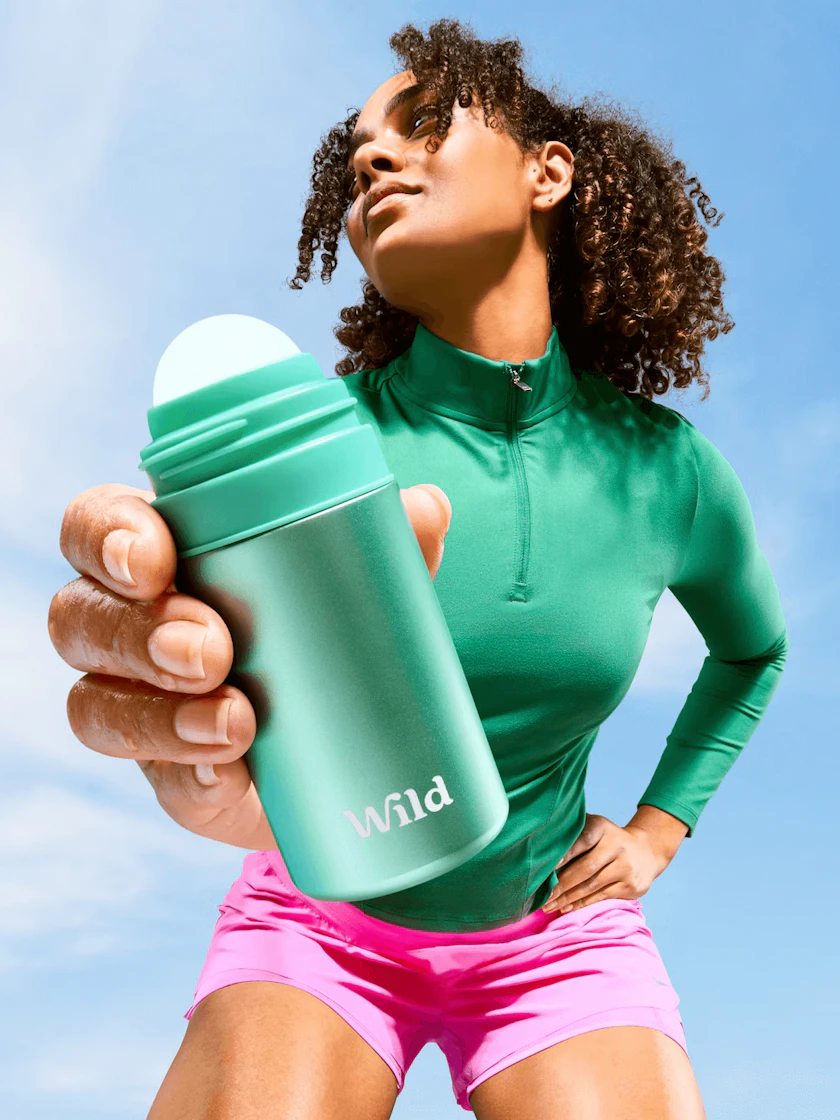 Caption: a woman in a green shirt holding a green water bottle