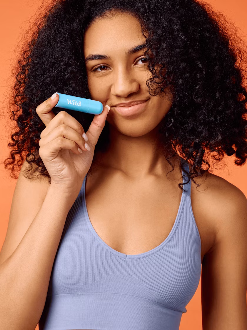 Caption: a woman holding a blue object in her right hand