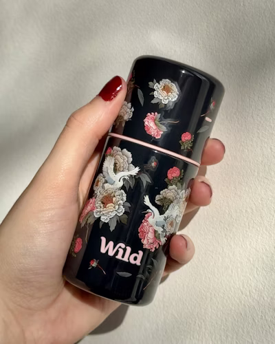 Caption: a woman holding a black coffee mug with flowers on it