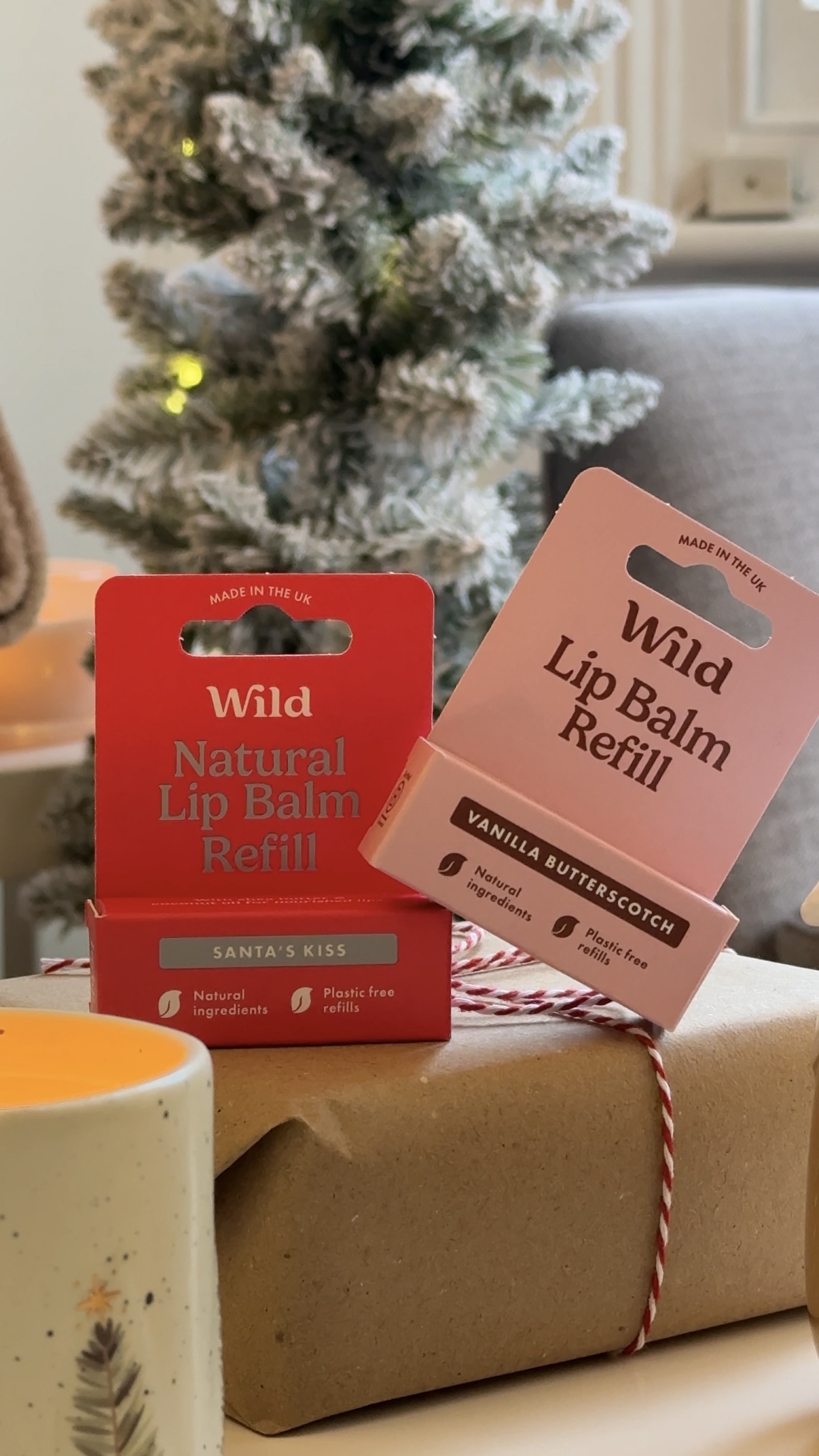 Caption: a box of lip balm next to a christmas tree