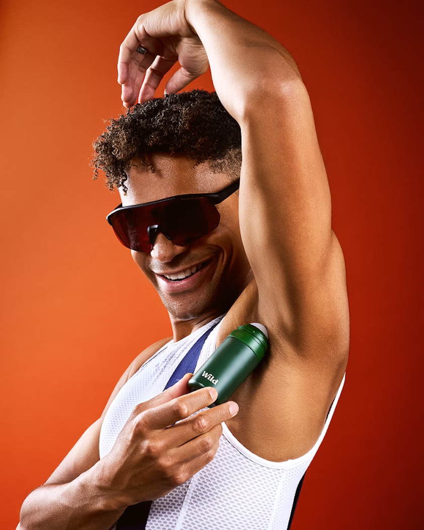 Caption: a man in a tank top and sunglasses holding a bottle