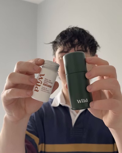 Caption: a man holding a cup of coffee in front of his face