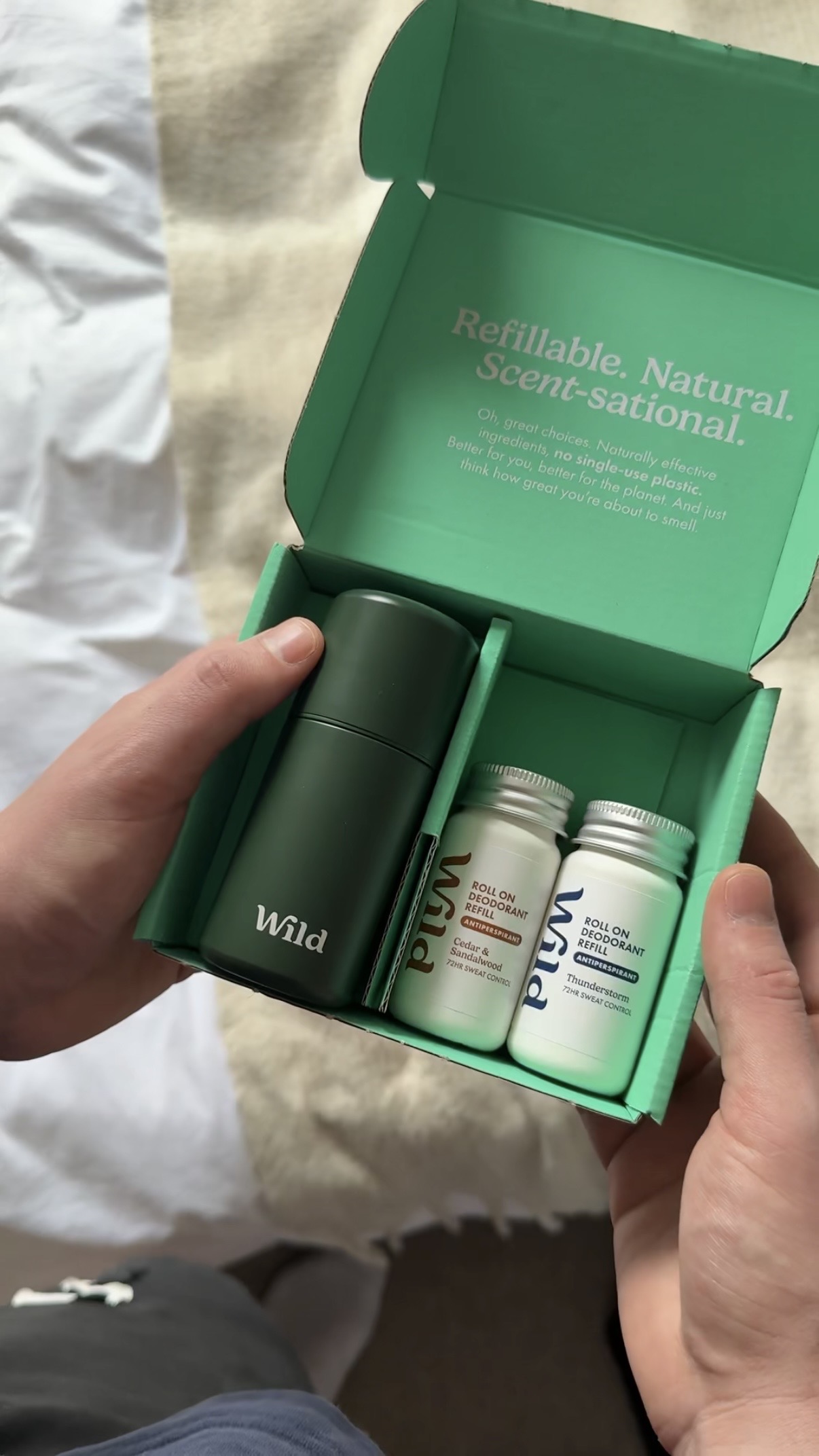 Caption: a person holding a green box with two bottles