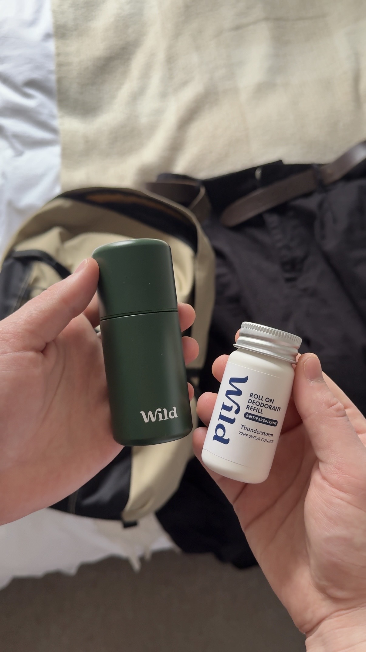 Caption: a person holding a bottle and a travel mug