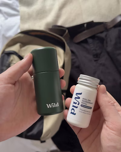 Caption: a person holding a bottle and a travel mug