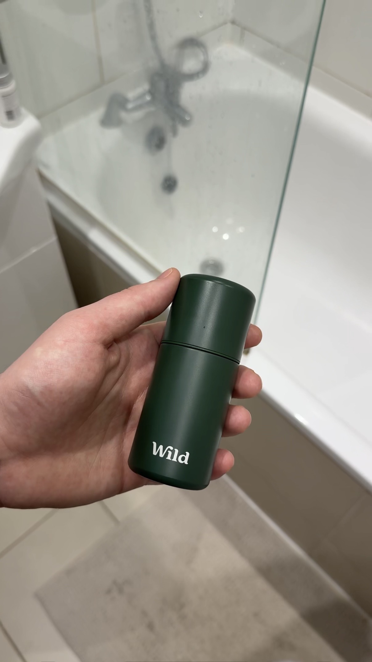 Caption: a person holding a travel mug in their hand